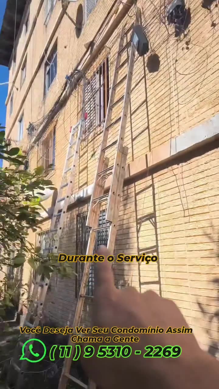 Técnico apontando a parte da instalação em que está trabalhando, com escada apoiada na parede